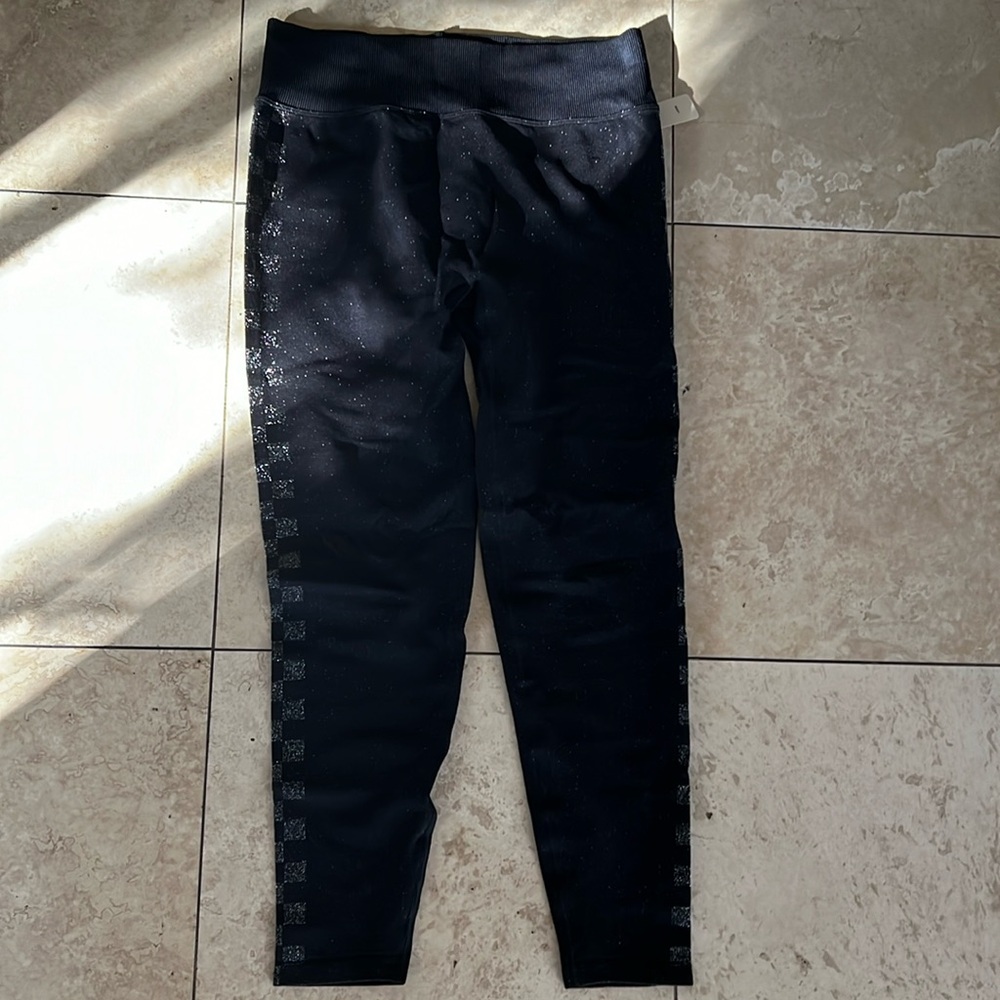 Pink seamless black leggings with checkered silver print on the sides. Size L.